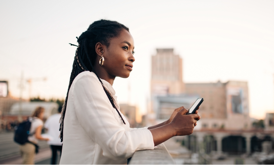 Mulher negra segurando celular