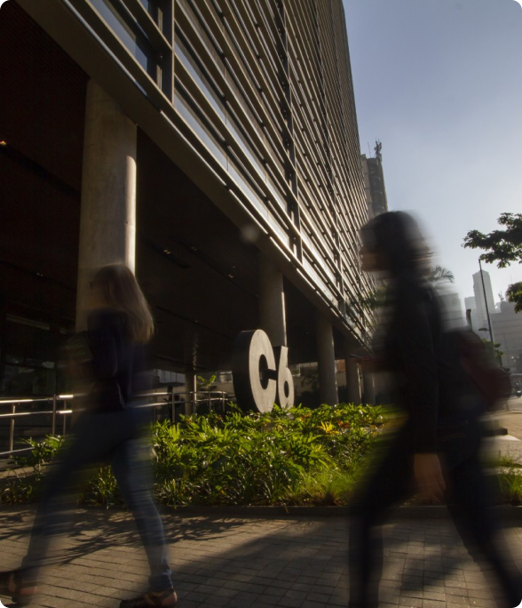 Pessoas caminhando em frente ao prédio do C6 Bank