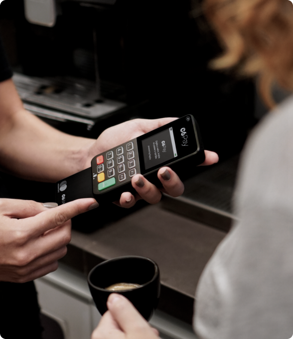 fotografia de pessoa segurando a maquininha do C6 Bank e inserindo um cartão C6 Carbon