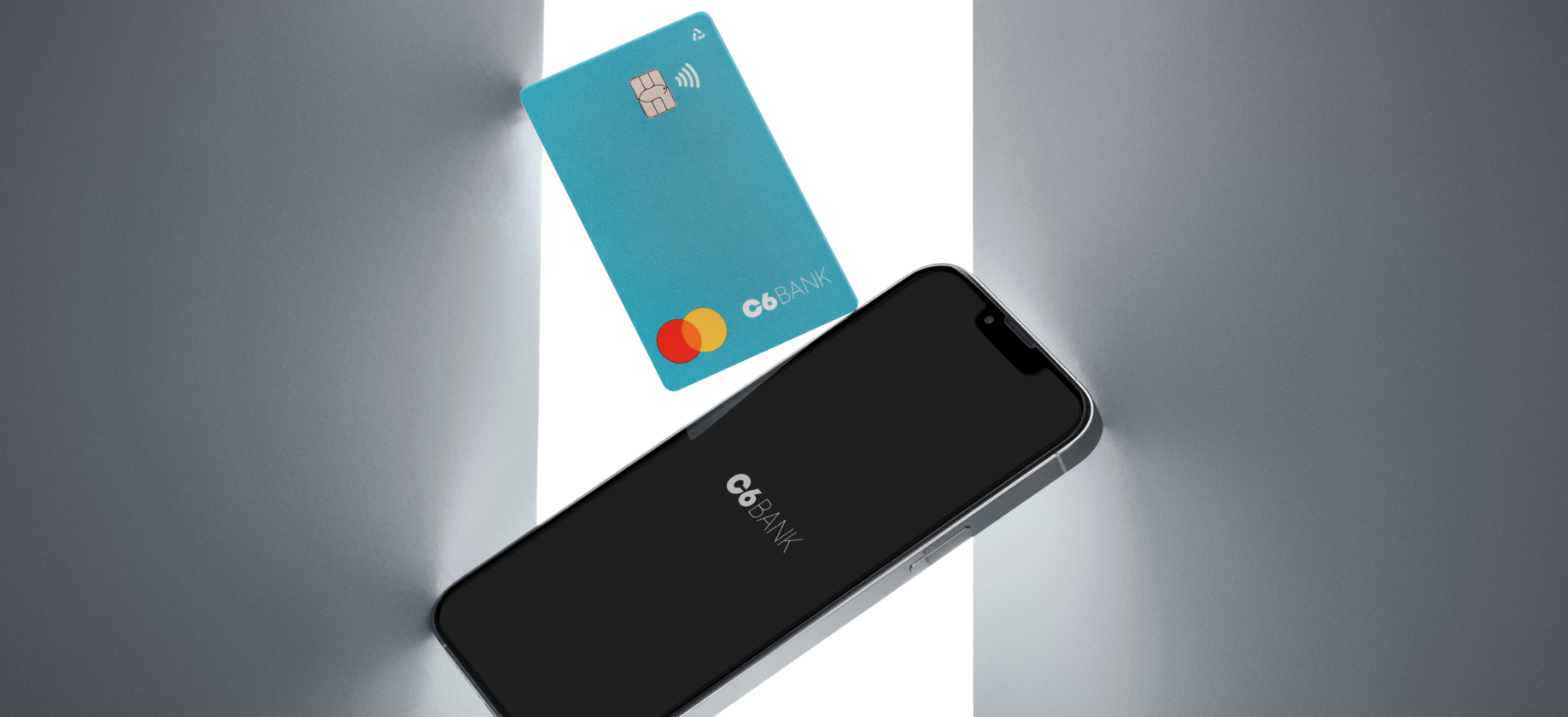 Foto de celular com a tela preta e logo do C6 Bank em branco e um cartão azul turquesa do C6 Bank acima.