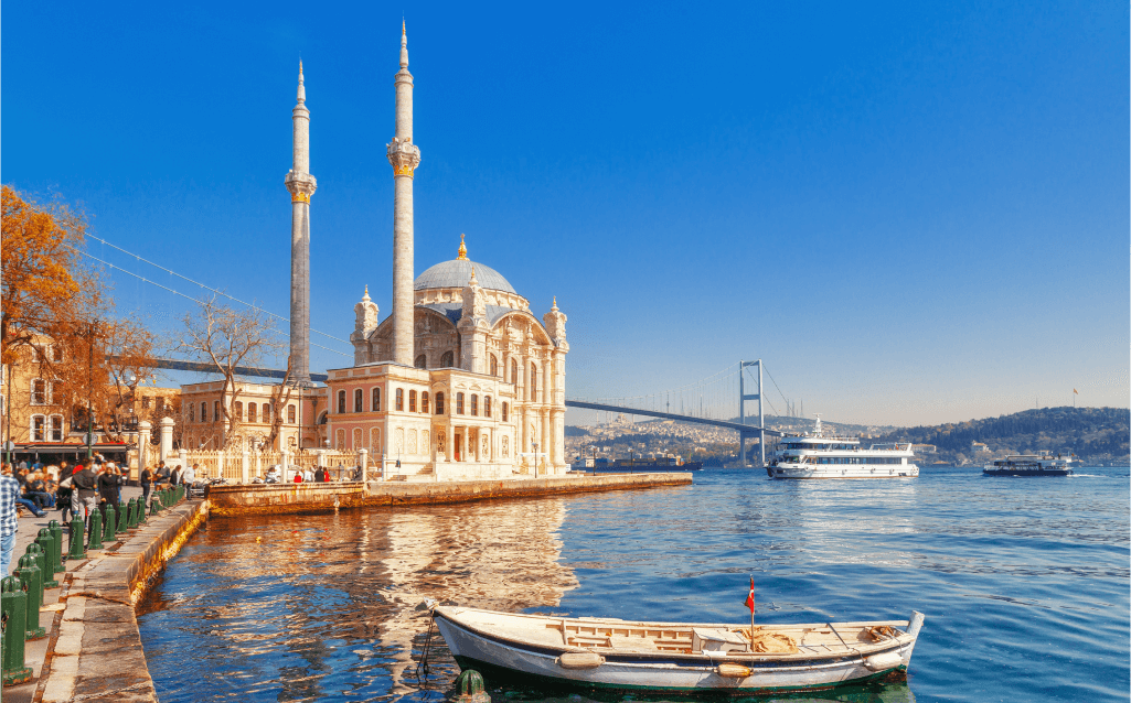 Vista da Mesquita de Ortaköy à beira do Estreito de Bósforo, com o mar e barcos ao fundo, em Istambul.