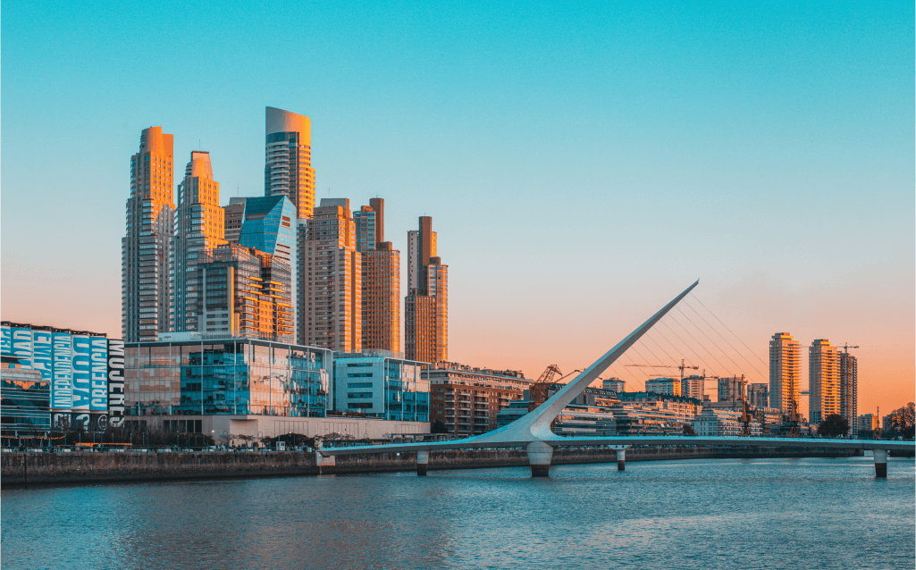 Vista do bairro de Puerto Madero em Buenos Aires, Argentina, com edifícios modernos ao pôr do sol.