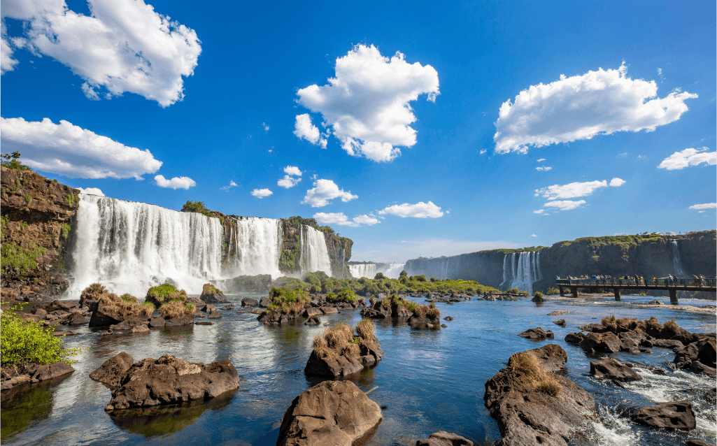 Vista das Cataratas do Iguaçu, no Paraná, com suas quedas d'água imponentes e céu azul.