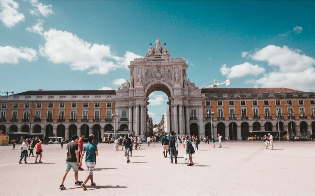 arco da rua augusta, portugal  monumento com um arco centralizado com esculturas no topo e a lateral com estruturas amarelas e sobre pilastras