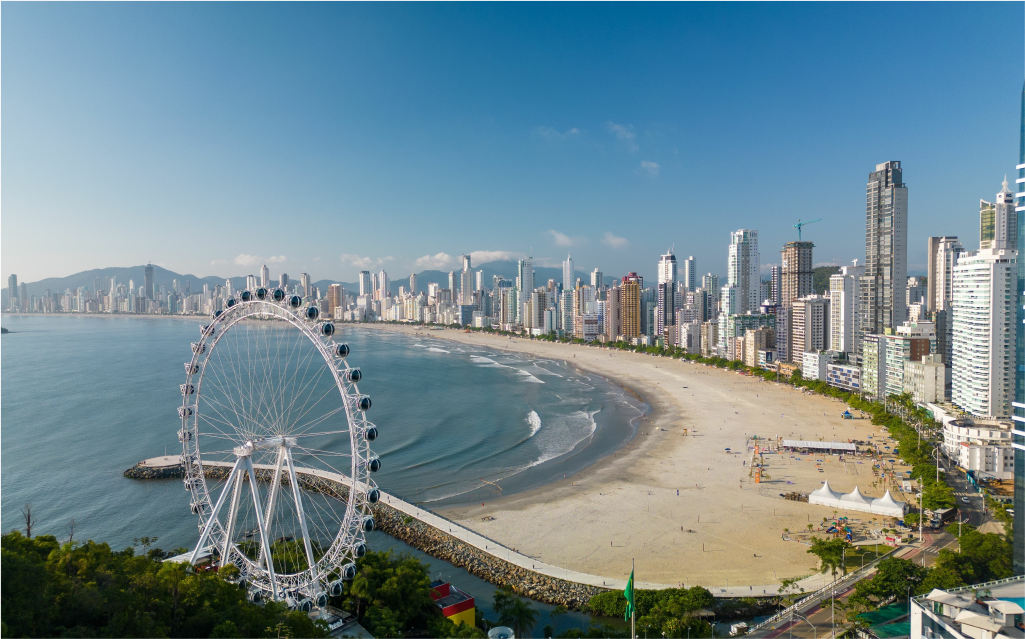 imagem da praia de balneário camboriú com uma roda gigante aparente