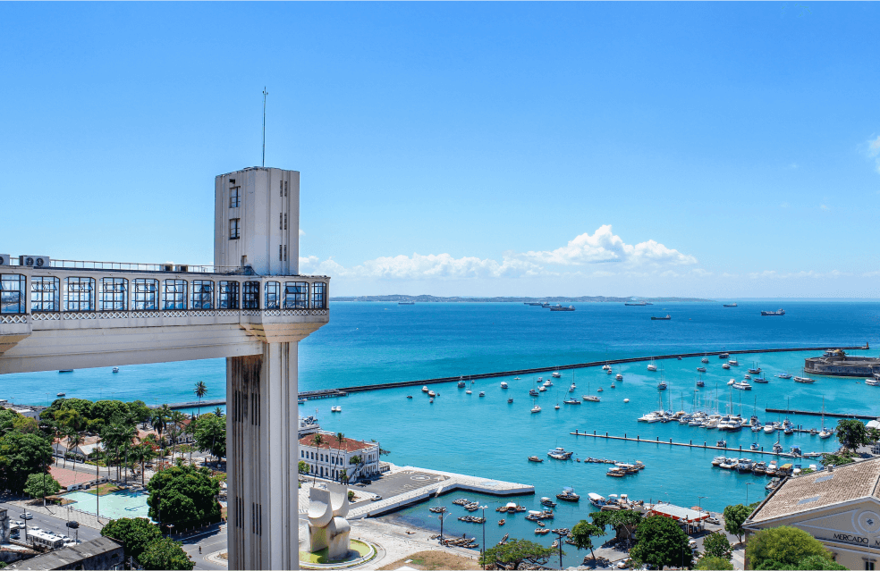 Farol com uma ponte na frente de uma marina de barcos.