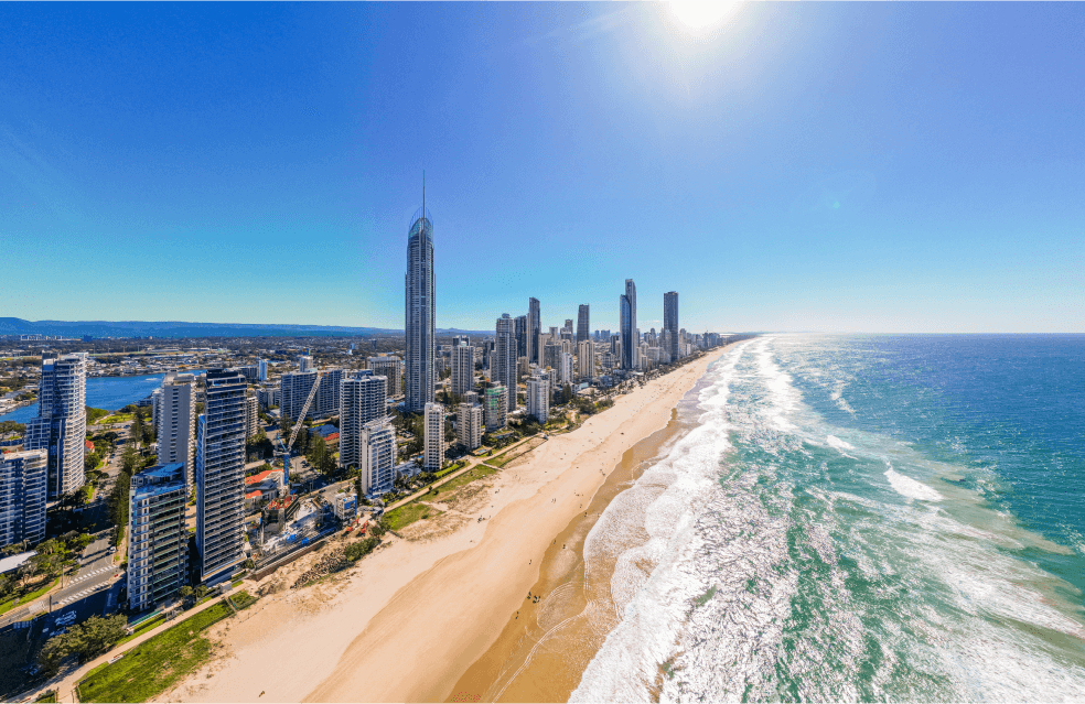 Foto de uma praia com prédios cercando a areia 