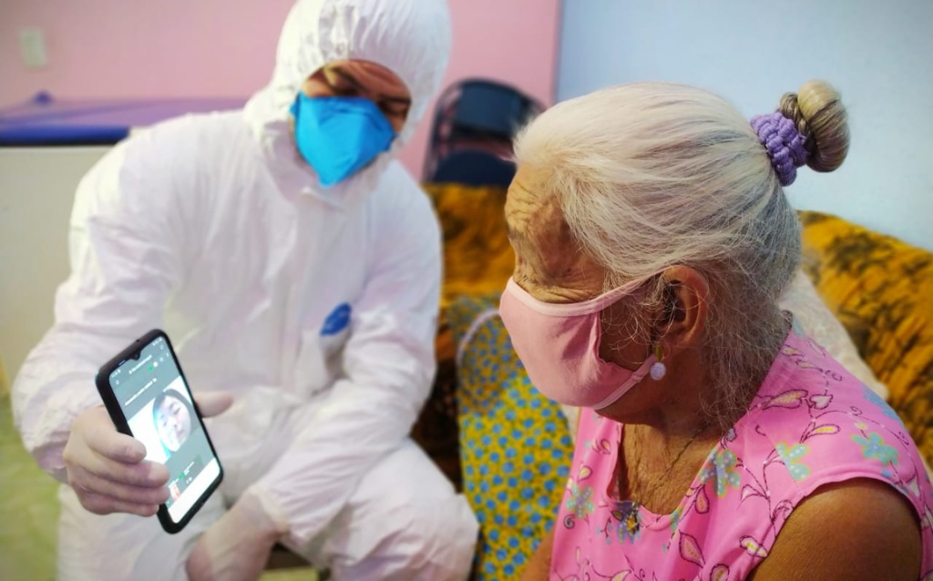 Homem médico vestido de branco atendendo uma senhora em uma iniciativa da SAS Brasil