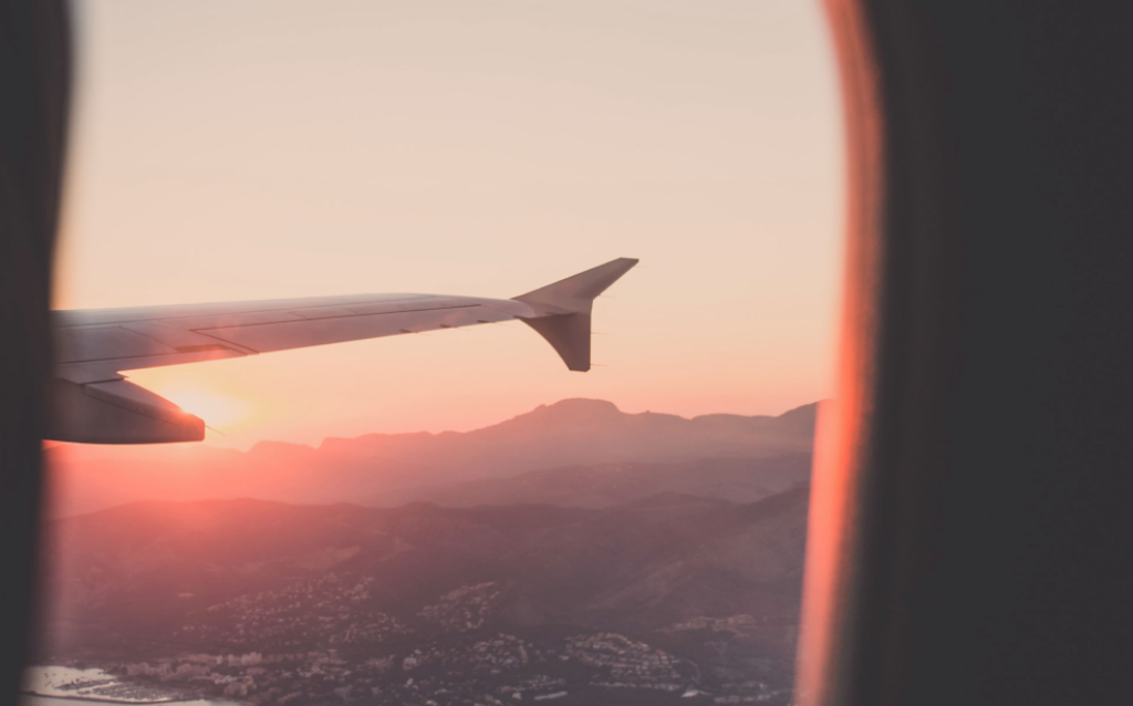 Foto de uma janela de avião com a vista para o horizonto para sinalizar a viagem internacional Carnaval