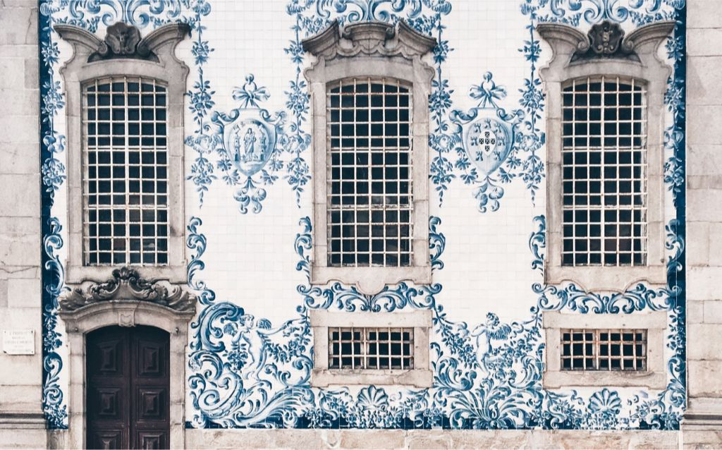 viajar para Portugal | parede com azulejos azuis, janelas grandes e de concreto, porta de madeira, arquitetura portuguesa